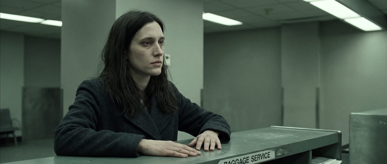 Alternate medium close-up of Elise at the counter, hands flat on the laminate, played by a lookalike generated from a written description rather than from reference photographs.